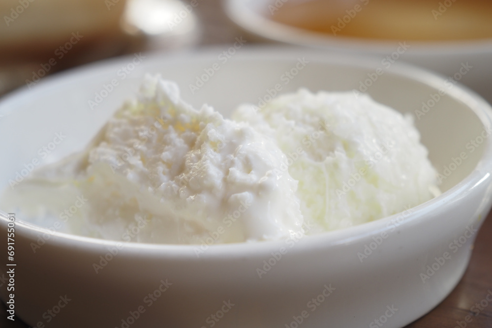 butter cream and honey in a bowl on table . butter cream and honey in a bowl on table .