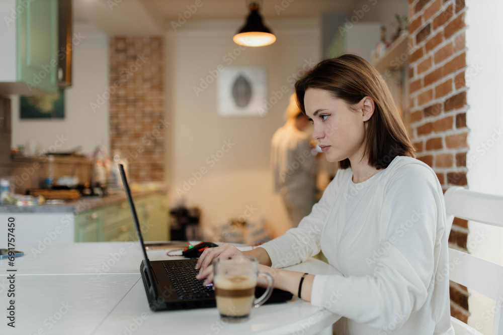 young woman working on a gaming laptop, playing on the Internet at home young woman working on a gaming laptop, playing on the Internet at home