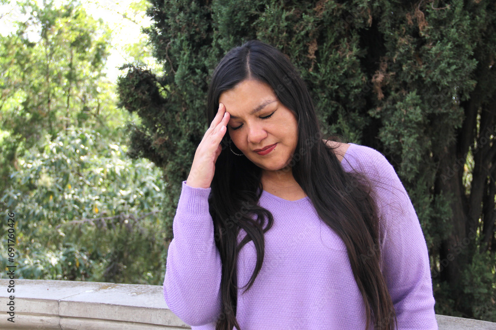 40-year-old Latina woman suffers from allergy headache outdoors 40-year-old Latina woman suffers from allergy headache outdoors