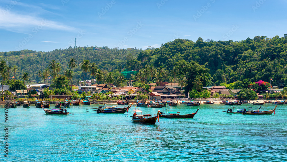 Longtail boats in turquoise water in beautiful beach lagoon in tropical island with resorts, Phi-Phi island, Krabi Province, Thailand