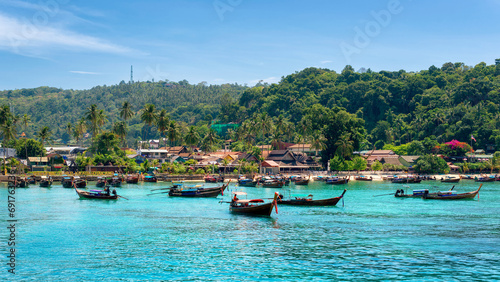 Longtail boats in turquoise water in beautiful beach lagoon in tropical island with resorts, Phi-Phi island, Krabi Province, Thailand photo