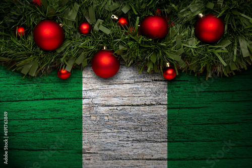 Christmas background made with garlands on a nigeria flag background. Christmas greeting from nigeria.