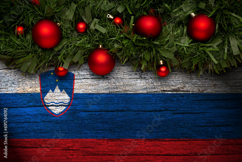 Christmas background made with garlands on a slovenia flag background. Christmas greeting from slovenia. photo