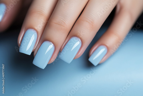 Glamour woman hand with baby blue nail polish on her fingernails. Blue nail manicure with gel polish at luxury beauty salon. Nail art and design. Female hand model. French manicure.