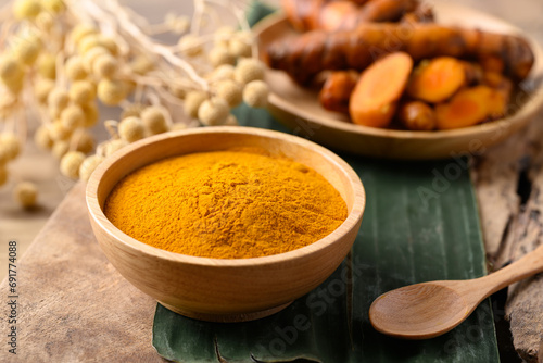 Turmeric powder and fresh turmeric in wooden bowl, Spice in Asian cuisine