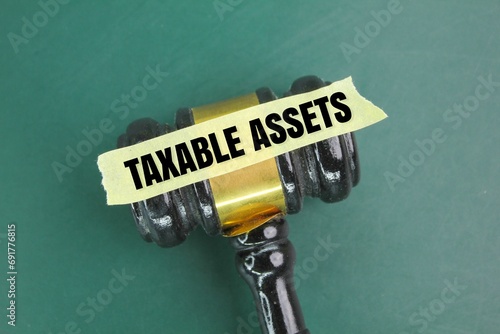 judge's gavel and a sticker with the word taxable asset. the concept of tax or asset tax