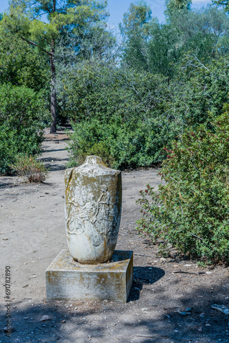Ancient stone urn on concrete plinths in garden part of the Agora ruins in Athens  Greece.