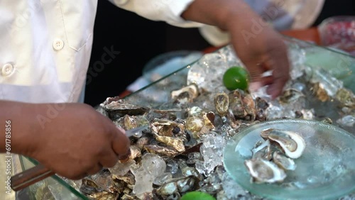 Chef preparando unas ostras crudas en una fiesta photo