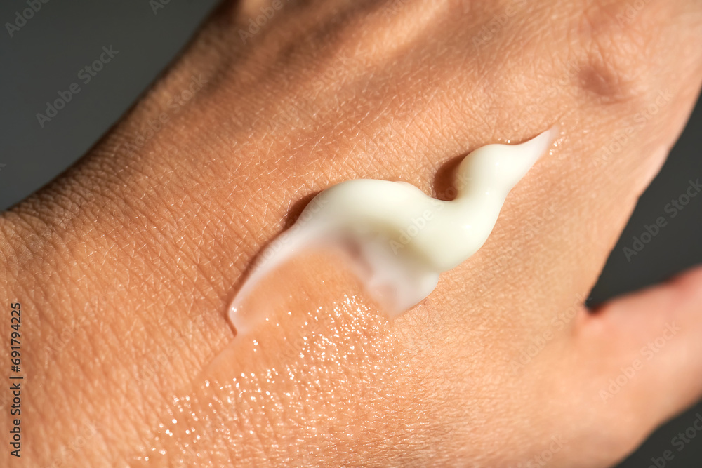 Fototapeta premium A smear of white moisturizer or sunscreen on a woman's hand.