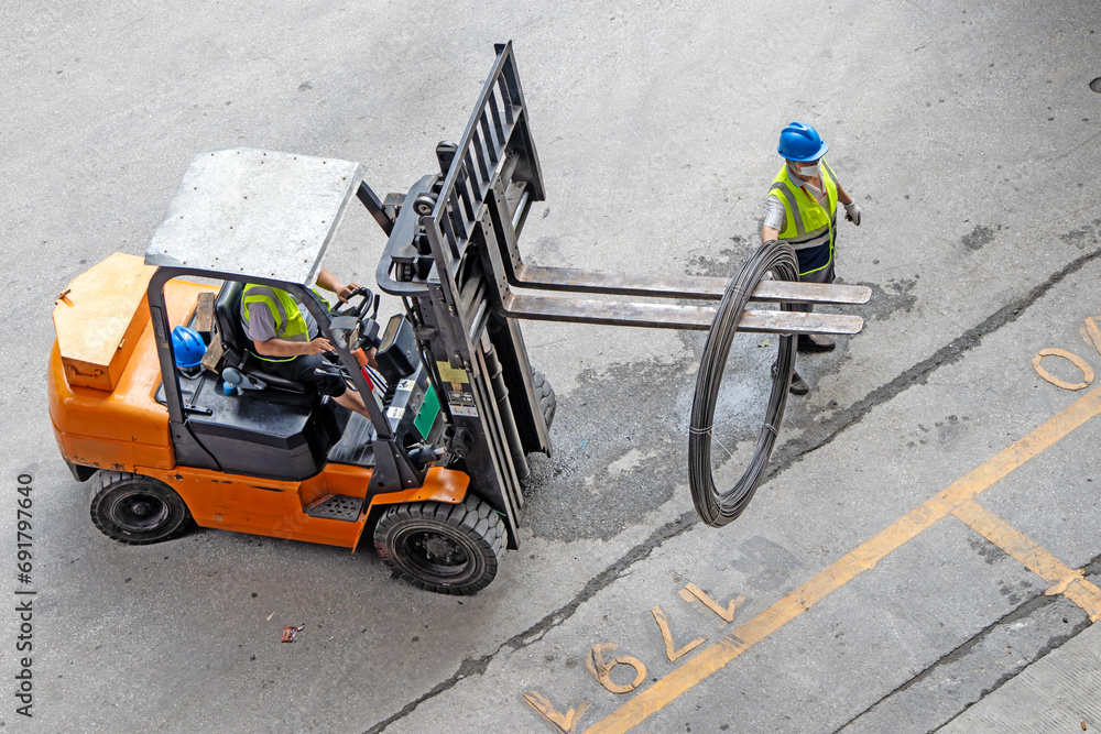 wire for loading a forklift, a large industrial forklift drives into a warehouse.