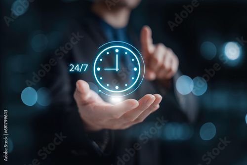 nonstop service concept. businessman hand holding virtual 24-7 with clock on hand for smart phone nonstop and full-time available contact of service concept. customer service. photo