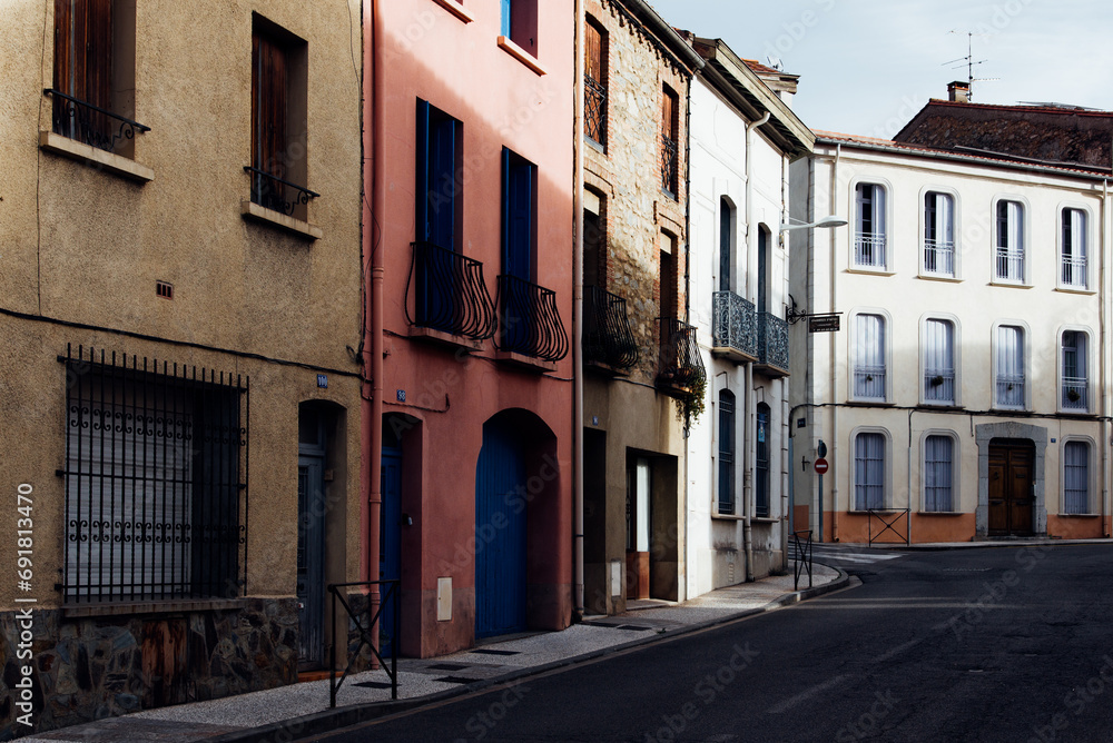 Rue vide dans une ville. Personne dans une rue. Absence de monde. Ville de Céret. Soleil et ombre dans une rue de ville méditerranéenne. Murs et façades de couleurs. 