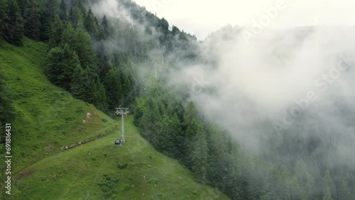 Rope way leading up a steep mountain on a very cloudy day in the Alps in Lofer, Austria. photo