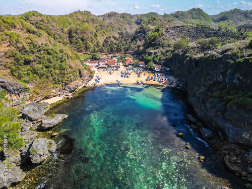Aerial view of Beautiful Traditonal Fisherman Village with many traditional fishing boat and rock cliffs on the beachside at Ngrenehan Beach, Gunungkidul, Yogyakarta In the morning sunny weather.