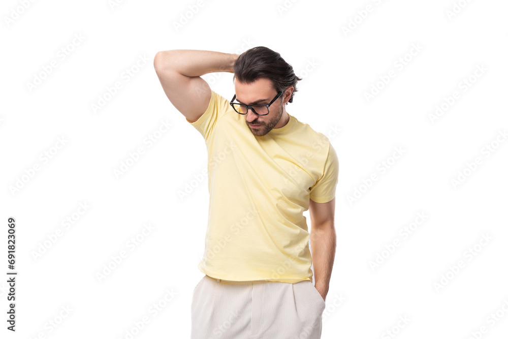 fashionable young successful European guy with stubble and mustache dressed in a light yellow T-shirt put on glasses fashionable young successful European guy with stubble and mustache dressed in a light yellow T-shirt put on glasses