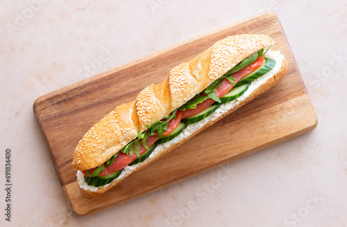 Sandwich with salmon, white cheese, cucumber and arugula. Breakfast. Fast food.