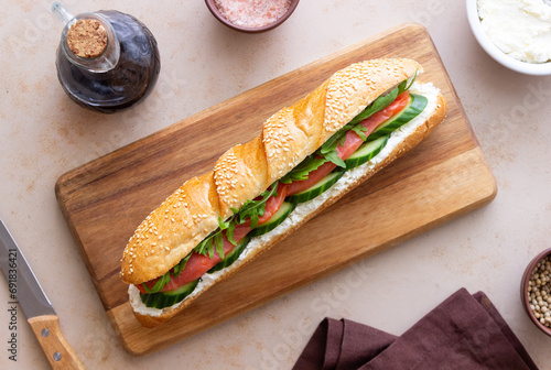 Sandwich with salmon, white cheese, cucumber and arugula. Breakfast. Fast food.