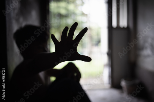 Child abuse concept, silhouette of  child confined in a dark room, prisoner or child abduction, child abuse human trafficking.