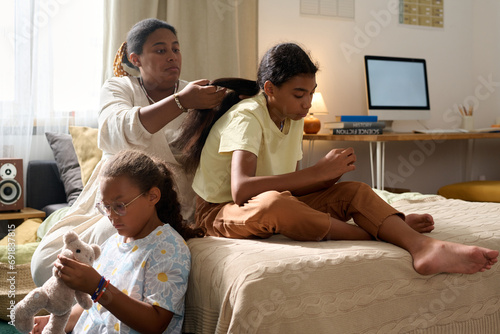 African American mother spending time with her daughters in the room photo