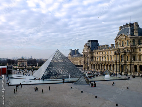 Tourists with the landmark pyramid outside the Louvre museum in Paris, France photo
