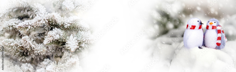 Two decorative penguins sit on the snow
Two decorative penguins sit on the snow