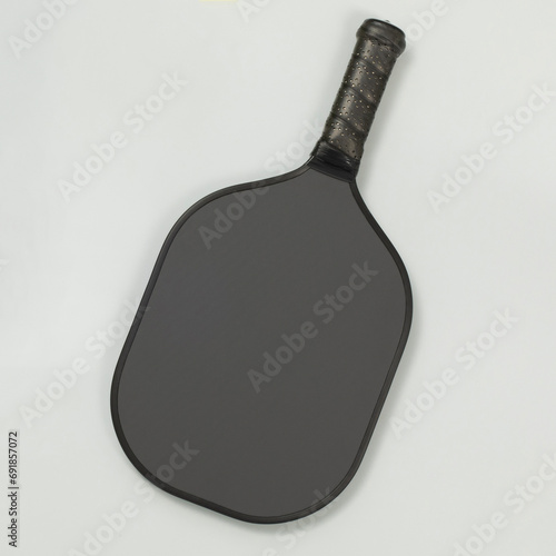 Valokuva Top view of a black blank pickleball paddle on light gray background with copy space