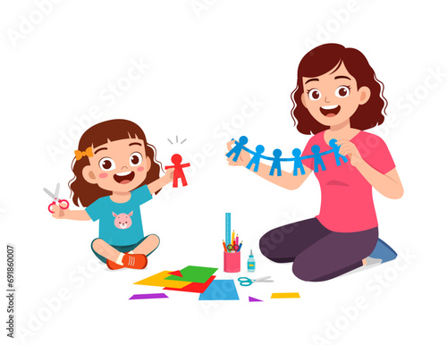 little kid make craft from paper with mother
