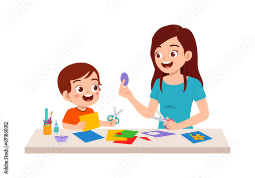little kid make craft from paper with mother