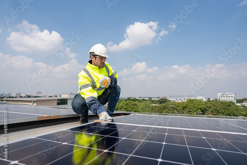 Engineers in helmets installing solar panel system outdoors. Installing a Solar Cell on a Roof. Solar panels on roof. Workers installing solar cell power plant eco technology.