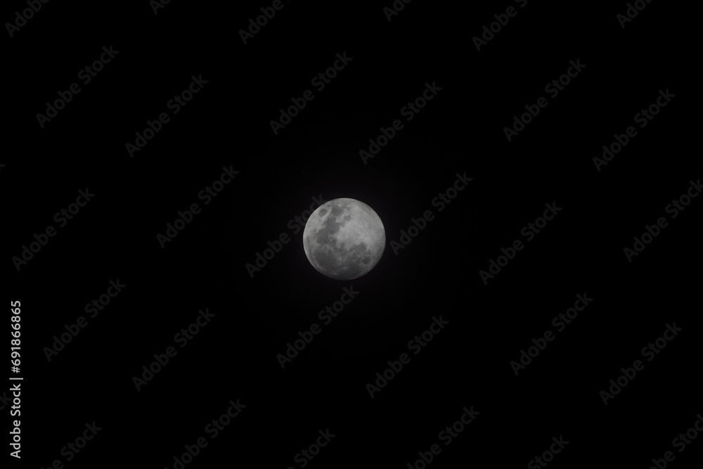 the moon seen through the night sky with clouds and trees the moon seen through the night sky with clouds and trees