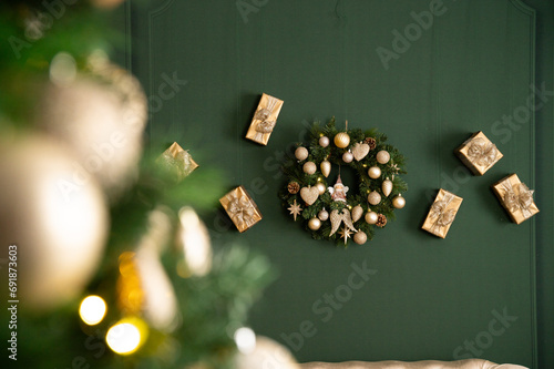 Beautiful Christmas New Year wreath on the wall, in a festive decor, surrounded by gifts, decorations and a Christmas tree. photo