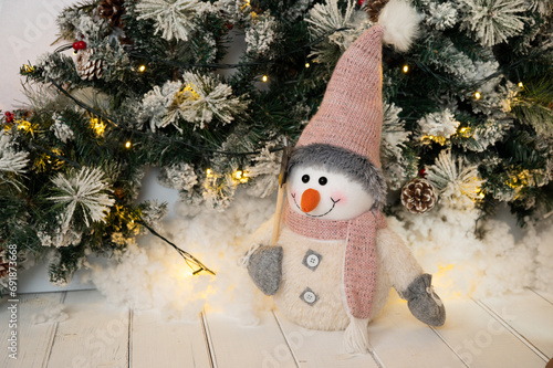 Gorgeous Christmas and New Year decor decorated with snowy tree branches, light and snowman photo