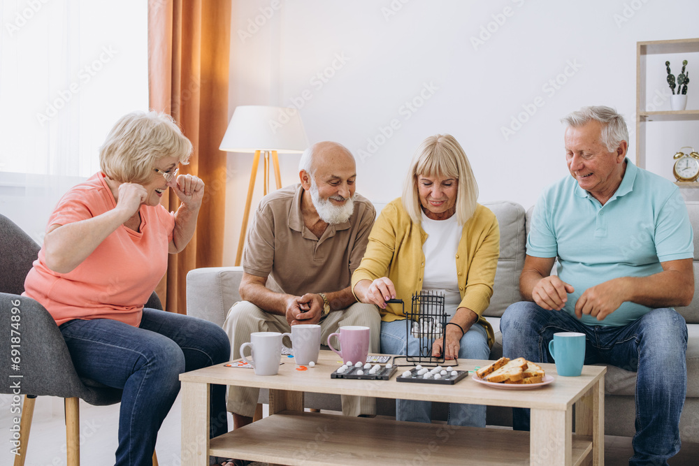 Group of four cheerful senior people playing bingo game in nursing home Group of four cheerful senior people playing bingo game in nursing home