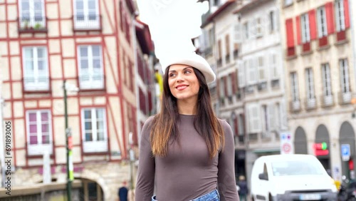 Vertical photo of a chic woman in beret sitting posing in the city photo