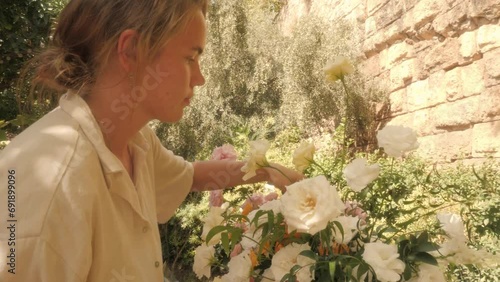 Woman florist create white rose flowers bouquet decor for summer garden party outdoor wedding