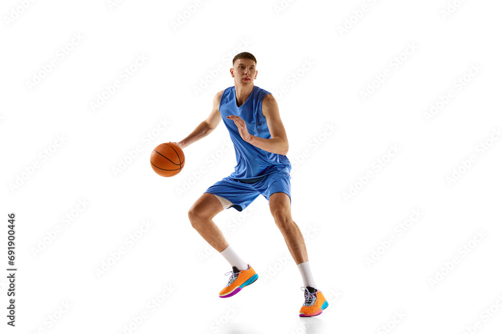 Dynamic image of young man in blue uniform, basketball player in motion during game, dribbling ball isolated on white background. Concept of sport, competition, match, championship, health, action. Ad Dynamic image of young man in blue uniform, basketball player in motion during game, dribbling ball isolated on white background. Concept of sport, competition, match, championship, health, action. Ad