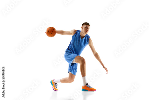 Dynamic image of young man in blue uniform  basketball player in motion during game  dribbling ball isolated on white background. Concept of sport  competition  match  championship  health  action. Ad