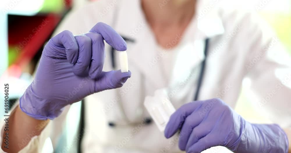 Doctor hands in gloves holds medical candles and vaginal pills. Treatment of prostatitis hemorrhoids and venereal diseases Doctor hands in gloves holds medical candles and vaginal pills. Treatment of prostatitis hemorrhoids and venereal diseases