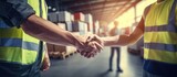 Close up hands of warehouse workers handshake for partnership in logistic center Industrial workers talking and deal for business in storehouse Working in Storage Distribution Center