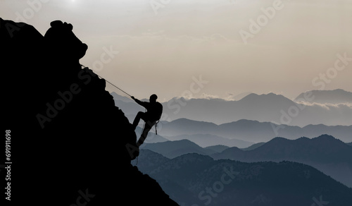 magnificent view of mountain ranges and man rock climbing alone