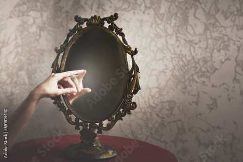 a person's hand touches his hand in the reflection of a mirror, abstract concept photo