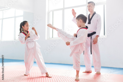 Young instructor teaching children Tae Kwon Do