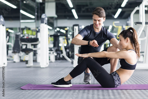 Young woman working with trainer at gym photo