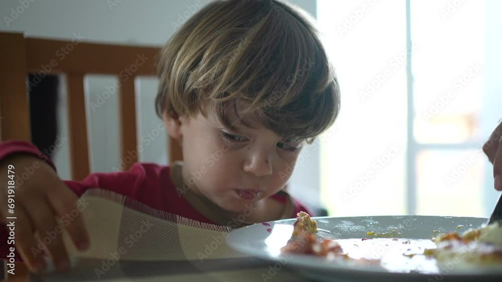 Feeding scrambled eggs to little boy during lunch time or breakfast, close-up of child being fed food by parent during family lifestyle scene Feeding scrambled eggs to little boy during lunch time or breakfast, close-up of child being fed food by parent during family lifestyle scene