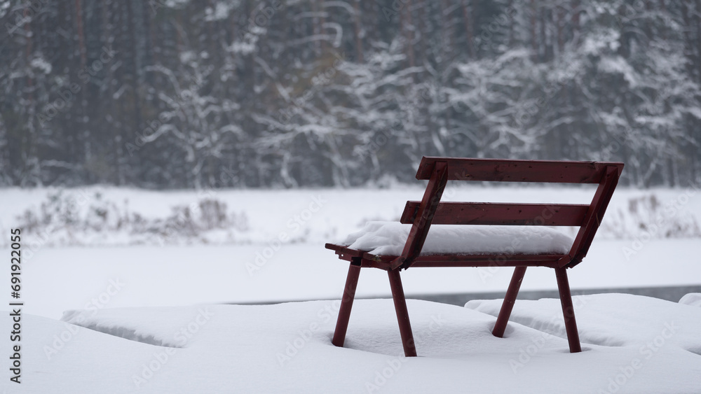 WINTER ATTACK - A bench and a fishing pier by the lake covered with snow