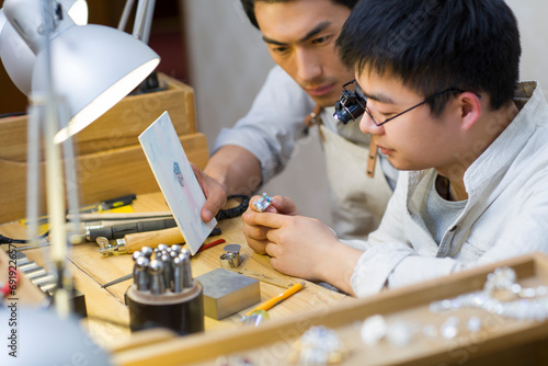 Male jewelers making a sapphire ring photo