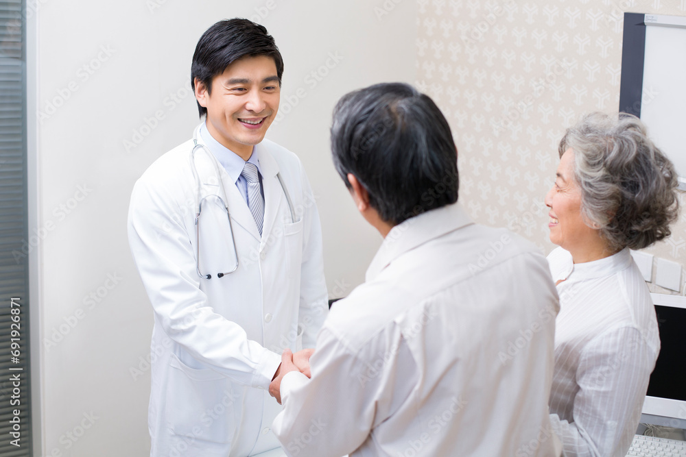 Senior couple shaking hands with doctor in hospital Senior couple shaking hands with doctor in hospital
