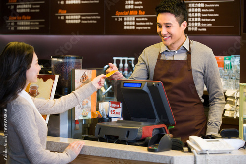 Customer paying by credit card in coffee shop photo