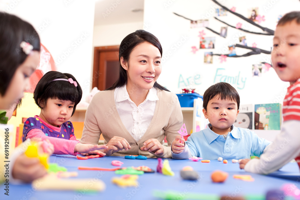 Kindergarten teacher and children playing with plasticine Kindergarten teacher and children playing with plasticine