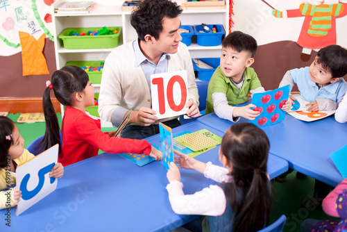 Kindergarten teacher teaching children maths photo